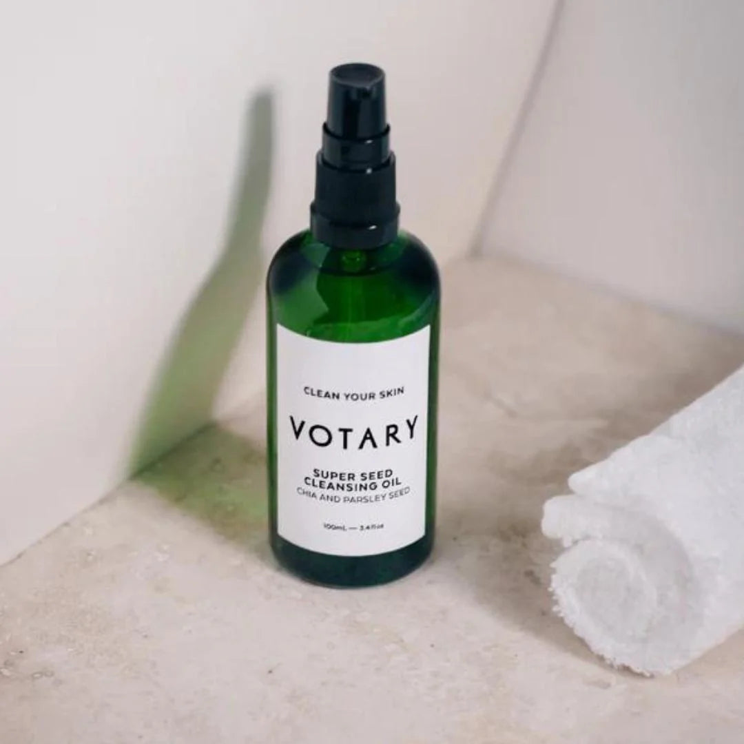 Votary Super Seed Cleansing Oil Chia & Parsley Seed 100ml – lifestyle flat lay: product bottle with botanical seed styling on neutral background