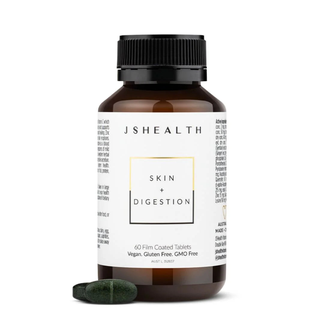 A bottle of JSHEALTH Skin + Digestion tablets with two dark green tablets in front, on a clean white background.