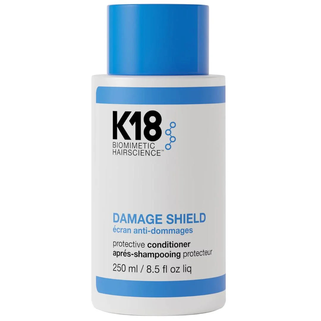 K18 Biomimetic Hairscience Damage Shield Protective Conditioner in a white bottle with a blue cap and blue accents on the label.