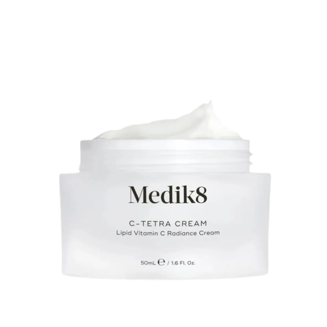 A white jar of Medik8 C-Tetra Cream with a dollop of white cream on top, set against a plain white background.