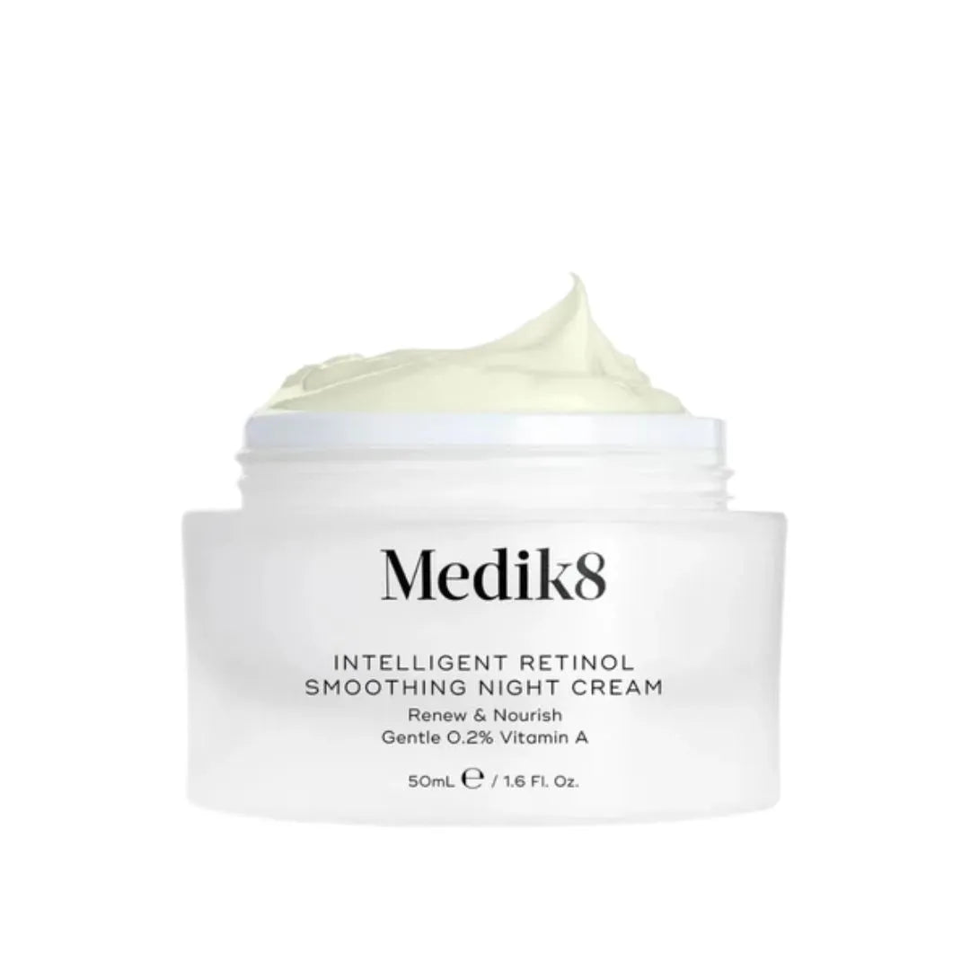 A white jar of Medik8 Intelligent Retinol Smoothing Night Cream with a dollop of pale yellow-green cream on top, set against a plain white background.