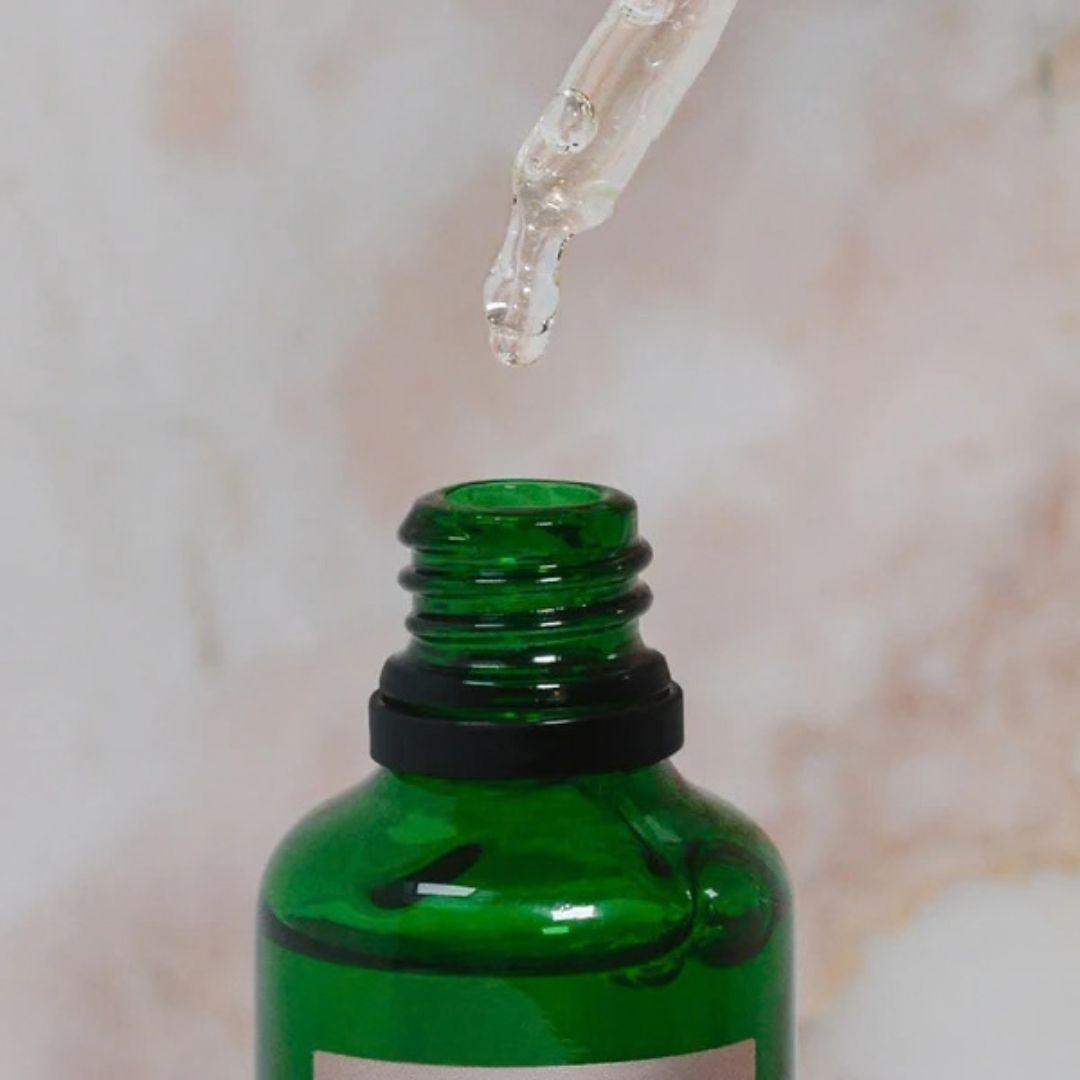 Votary Brightening Hyaluronic Serum lightweight hydrating serum texture shown dripping from glass dropper into green bottle