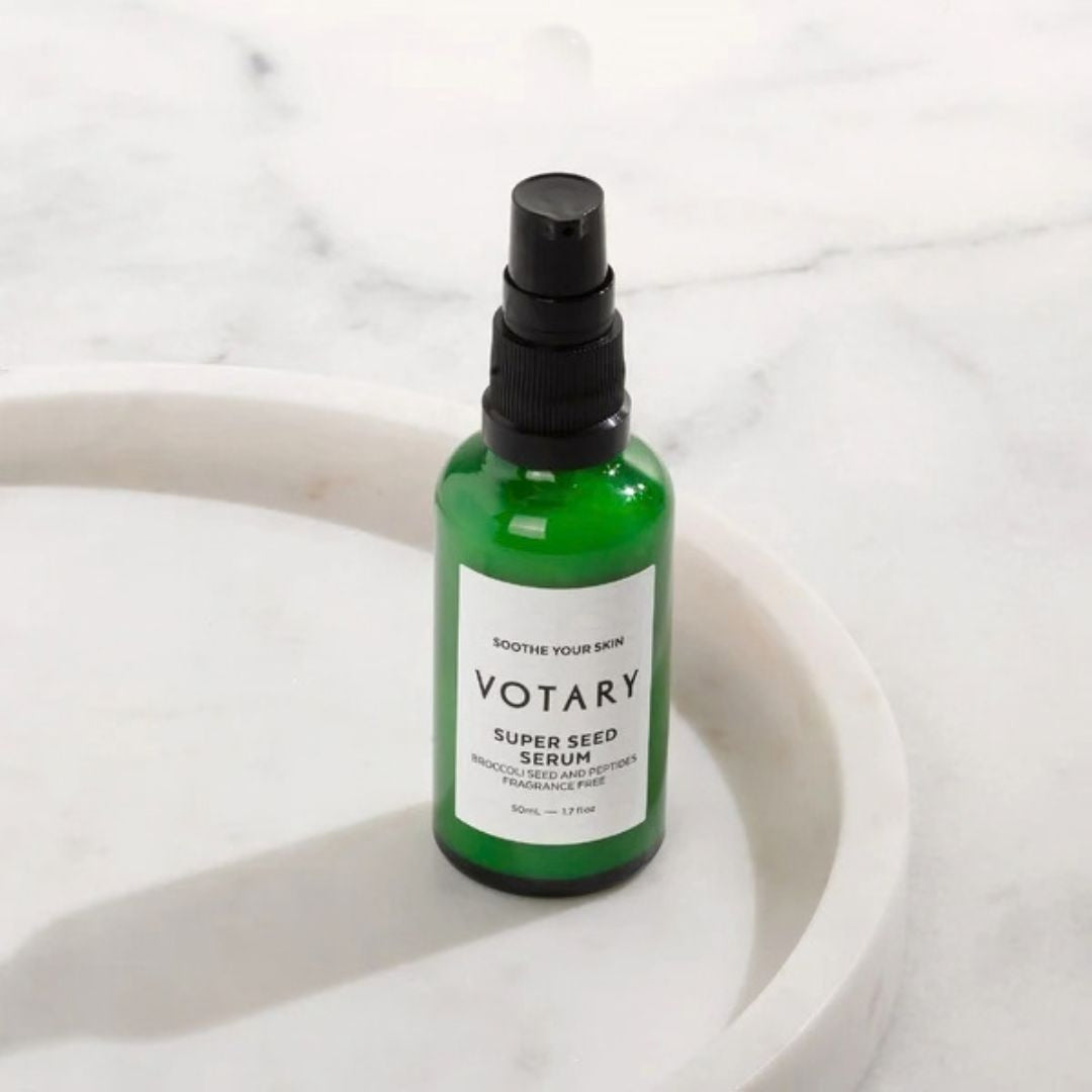 Votary Super Seed Serum with broccoli seed and peptides in green pump bottle displayed on marble surface