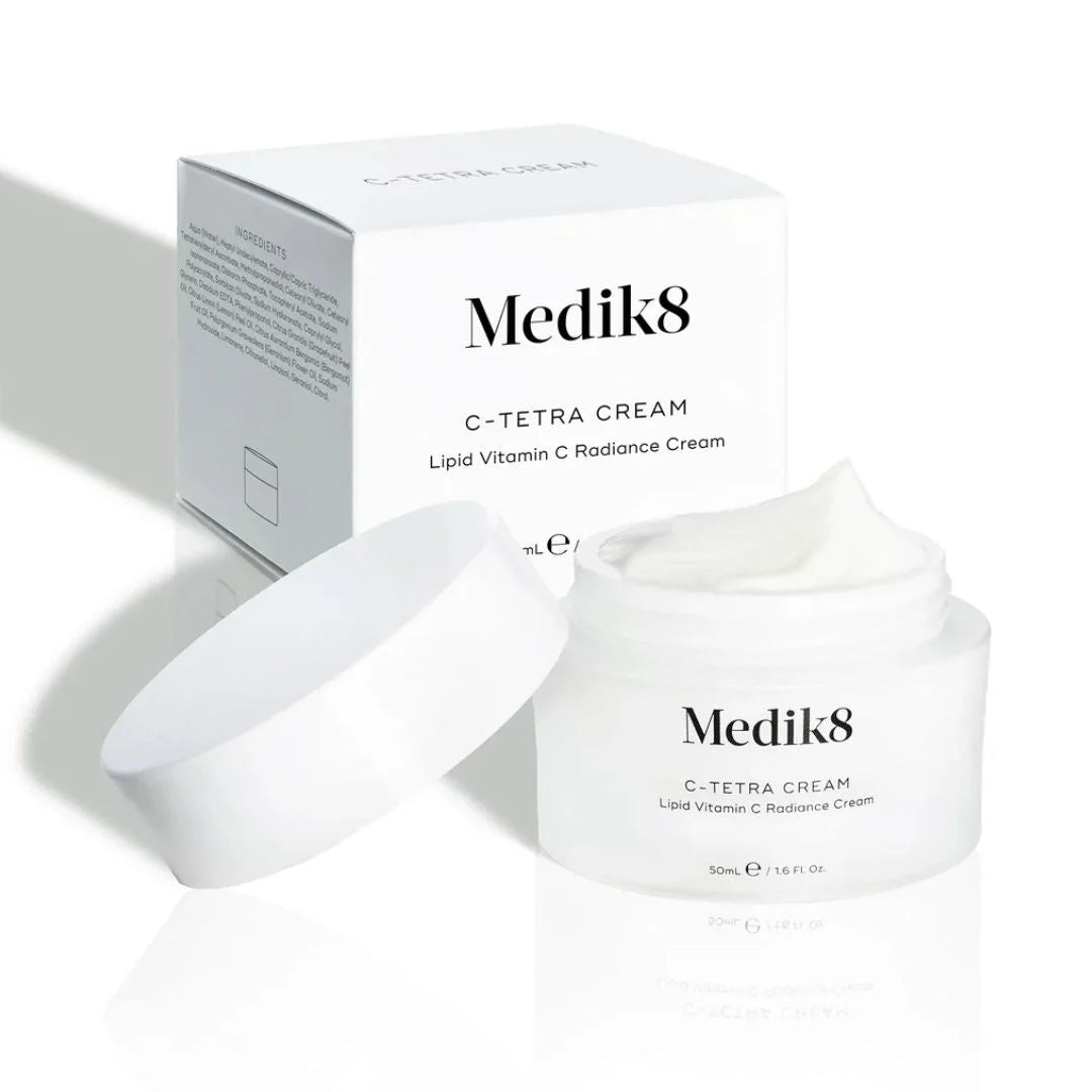 Medik8 C-Tetra Cream shown with its white product box, open jar containing white cream, and detached white lid on a clean white reflective surface.