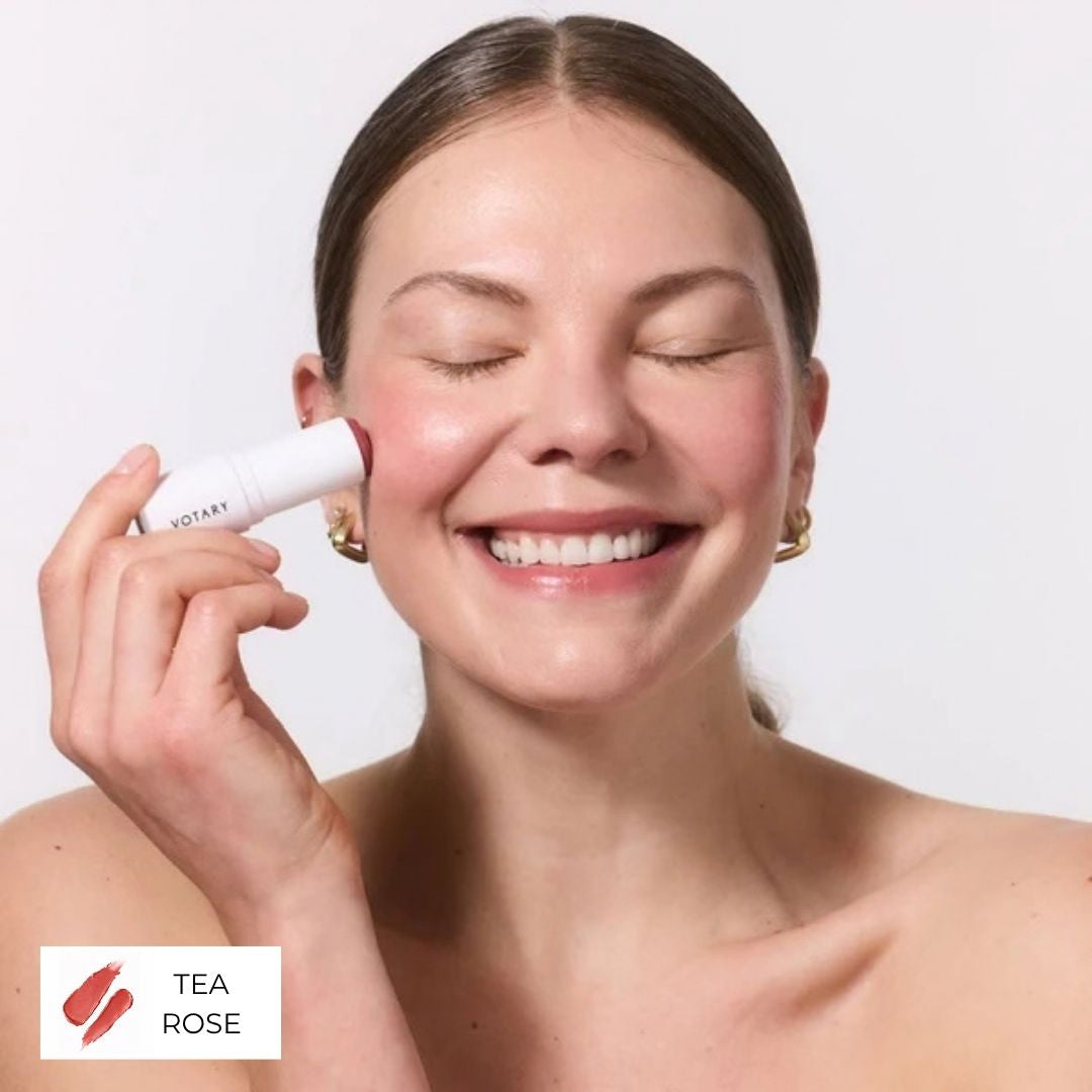 Votary Lip & Cheek Tint in Tea Rose with a dusty rose-red tip applied to cheek.