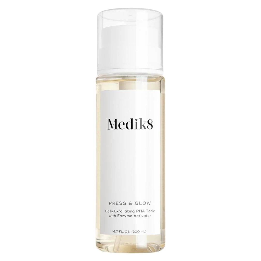 A clear bottle of Medik8 Press & Glow serum with a white pump and a white label, containing a pale yellow liquid, set against a plain white background.