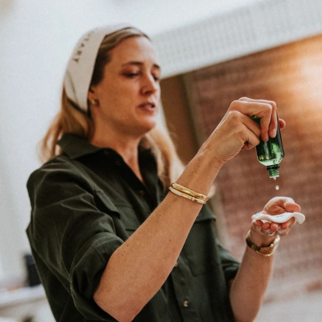 Woman applying Votary Daily Apple Toner with AHAs and prebiotics to a reusable cotton pad