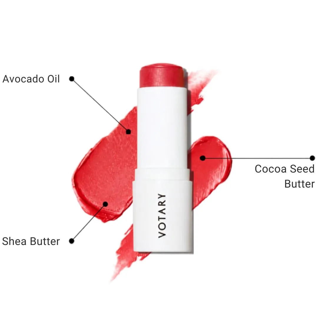 VOTARY Lip and Cheek Tint tube in a red shade, shown with red product swatches behind it and callout labels reading Avocado Oil, Shea Butter, and Cocoa Seed Butter on a white background.