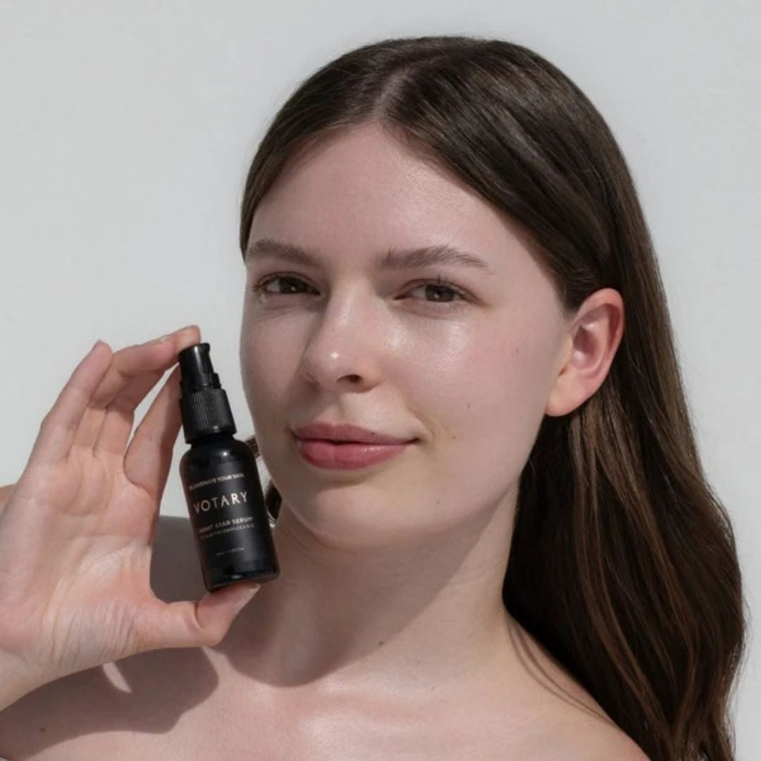 Woman holding Votary Night Star Serum beside her face for a calming skincare routine