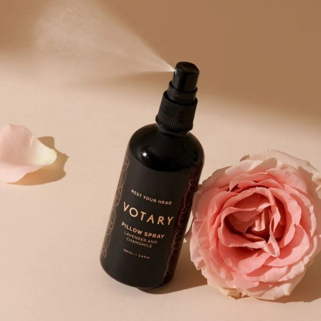 Votary Pillow Spray with Lavender and Chamomile displayed beside a pink rose