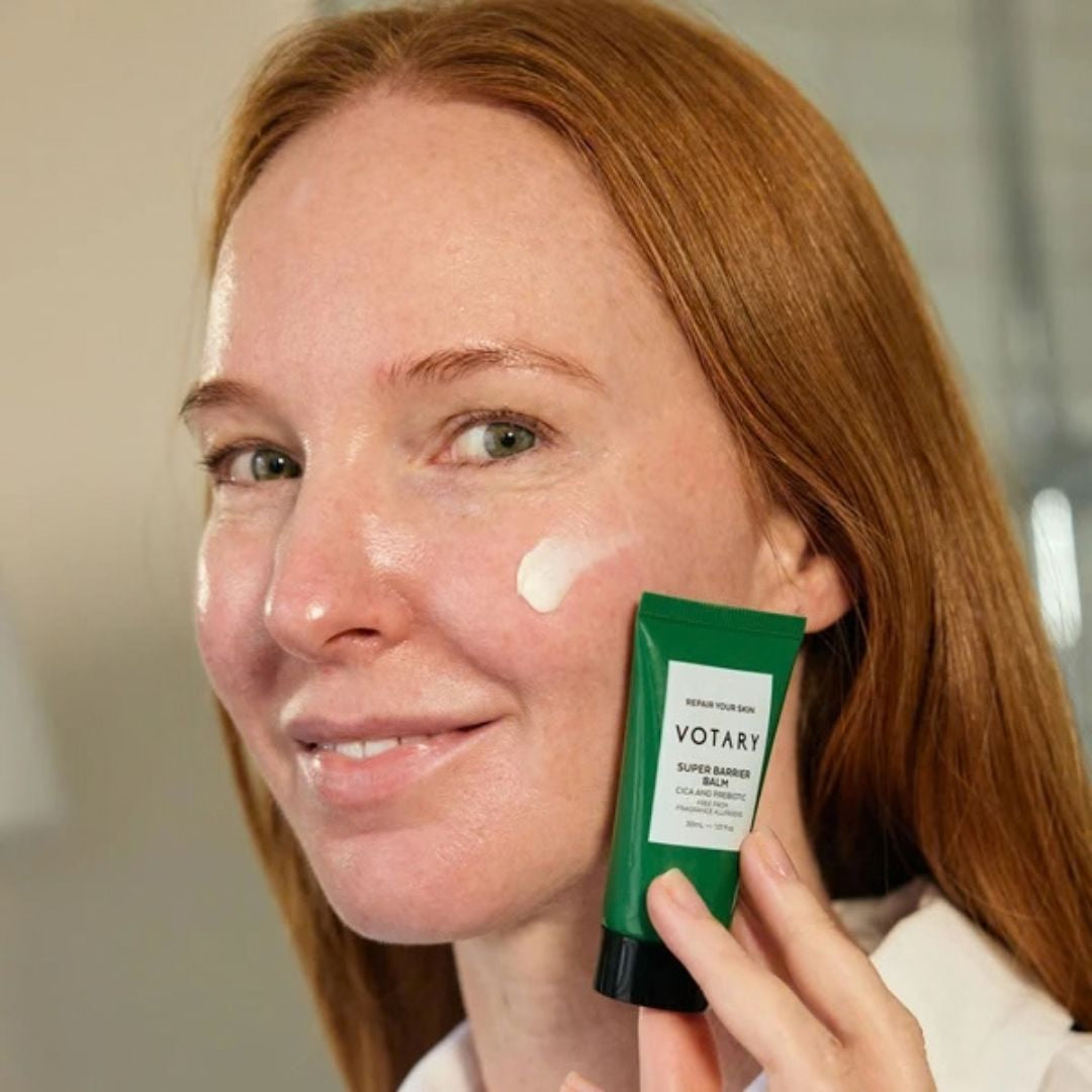 Woman applying Votary Super Barrier Balm with Cica and Probiotics to her cheek